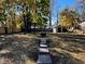 Large backyard featuring a fire pit, stepping stones, trees, shed and wood fence at 212 S Good Ave, Indianapolis, IN 46219