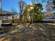 A spacious backyard with mature trees, stepping stones, and a wood fence at 212 S Good Ave, Indianapolis, IN 46219