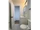 Bathroom with black and white tile, cabinet sink, and open door leading to closet at 212 S Good Ave, Indianapolis, IN 46219