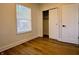Bright bedroom with wood flooring, a window, and closet with sliding door at 212 S Good Ave, Indianapolis, IN 46219