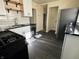 Renovated kitchen features black appliances, white cabinets, floating shelves and subway tile backsplash at 212 S Good Ave, Indianapolis, IN 46219