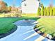 Landscaped backyard with a stone fire pit, lush green grass, and a walkway leading to the house at 5778 W Commonview Dr, McCordsville, IN 46055