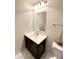 This half bath includes hexagon tile flooring, a dark vanity, a white sink and a decorative boat on the commode at 5778 W Commonview Dr, McCordsville, IN 46055