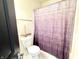 The half bathroom features a dark shower curtain and commode with a white, decorative boat sitting atop the tank at 5778 W Commonview Dr, McCordsville, IN 46055