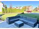 This backyard patio features a dark gray wicker outdoor seating set and a view of the green lawn at 5778 W Commonview Dr, McCordsville, IN 46055