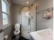 Updated bathroom features a glass shower, toilet, and sleek vanity with a window at 839 Fernwood Ct, Indianapolis, IN 46234