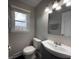 Updated half bath with a modern vanity, toilet, mirror, and natural light from the window at 839 Fernwood Ct, Indianapolis, IN 46234
