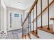 Welcoming foyer with wooden staircase and natural light streaming through the front door window at 839 Fernwood Ct, Indianapolis, IN 46234