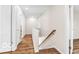 An upstairs hallway with wood floors and white doors, featuring a wood railing at 839 Fernwood Ct, Indianapolis, IN 46234
