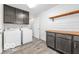 Bright laundry room featuring front loading washer and dryer, wood-look floors, shaker cabinets, and wood countertop folding surface at 839 Fernwood Ct, Indianapolis, IN 46234