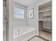Inviting bathroom featuring a modern tub with fixtures and a well-organized closet at 1775 Beyers St, Fortville, IN 46040