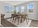 Bright dining room featuring a wood table, modern chairs, a stylish rug, and an abundance of natural light from multiple windows at 1775 Beyers St, Fortville, IN 46040