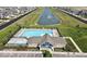 Aerial view of a community pool, hot tub, pool house, landscaping, and parking lot surrounded by green space at 1775 Beyers St, Fortville, IN 46040