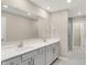 Modern bathroom featuring double sinks, sleek vanity, large mirror and a glass-enclosed shower at 18322 Depoe Ln, Westfield, IN 46074