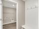 Hallway with coat hooks leading to the laundry room with vinyl flooring and shelving at 18322 Depoe Ln, Westfield, IN 46074