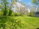 Lush backyard featuring a fire pit area surrounded by mature trees and green grass at 104 W County Road 500 S, Clayton, IN 46118