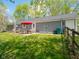 Relaxing patio with outdoor dining set, open backyard with lush green grass, and a fenced perimeter at 104 W County Road 500 S, Clayton, IN 46118