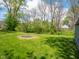 Large backyard with fire pit area and lush green lawn surrounded by mature trees at 104 W County Road 500 S, Clayton, IN 46118