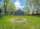 Backyard features a shed, fire pit, lush green grass and surrounding trees at 104 W County Road 500 S, Clayton, IN 46118