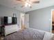 Neutral bedroom features modern ceiling fan, wood-look floors, television, and white dresser at 104 W County Road 500 S, Clayton, IN 46118