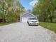 Wide gravel driveway with a detached garage and parked car at 104 W County Road 500 S, Clayton, IN 46118
