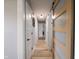 A bright hallway featuring wood-look floors, neutral walls, and stylish doors at 104 W County Road 500 S, Clayton, IN 46118