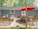 Cozy outdoor patio with dining set, shaded by a vibrant red umbrella and accented by string lights at 104 W County Road 500 S, Clayton, IN 46118