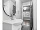 Bathroom featuring modern faucet, round mirror, tiled shower, and neutral color palette at 1829 New St, Indianapolis, IN 46203