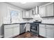 Bright kitchen showcases stainless steel appliances, white cabinets, marble backsplash, and dark countertop at 1829 New St, Indianapolis, IN 46203