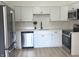 Modern kitchen with white cabinets, stainless appliances, subway tile, and light vinyl flooring. Ready for cooking! at 5215 Fawn Hill Ter, Indianapolis, IN 46226