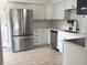 Bright kitchen featuring white cabinets, stainless steel appliances, a subway tile backsplash, and durable vinyl flooring at 5215 Fawn Hill Ter, Indianapolis, IN 46226