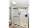 Bathroom with a walk-in shower featuring white tiles, shower head, and shelving at 8528 Quail Hollow Rd, Indianapolis, IN 46260