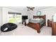 Spacious bedroom featuring a king-size bed, ceiling fan, and a large window at 8528 Quail Hollow Rd, Indianapolis, IN 46260