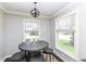 Cozy breakfast nook with a round table, three stools, and natural light from two windows at 8528 Quail Hollow Rd, Indianapolis, IN 46260