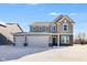 Two-story home showcasing a 3 car garage and brick and vinyl siding, front yard covered in fresh snow at 1095 Bevy Blvd, Danville, IN 46122