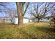 Spacious backyard featuring lush greenery, a white shed, mature trees, and a glimpse of the home at 825 Arrow Ave, Anderson, IN 46016