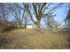 Expansive backyard featuring mature trees and a detached garage, offering ample outdoor space at 825 Arrow Ave, Anderson, IN 46016