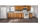 Bright kitchen features wood cabinets, stove, fridge, and modern tile backsplash at 825 Arrow Ave, Anderson, IN 46016