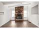 Spacious living room featuring hardwood floors, a brick fireplace, and lots of natural light at 825 Arrow Ave, Anderson, IN 46016