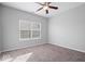 Neutral bedroom features carpeted floors, a ceiling fan, and a large window for natural light at 10034 Evening Sun Ct, Avon, IN 46123