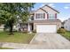 Attractive home with a brick accent wall and a spacious two-car garage and well manicured lawn at 10034 Evening Sun Ct, Avon, IN 46123