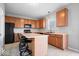 Well-lit kitchen features wood cabinets, a black refrigerator, and an eat-in island with seating at 10034 Evening Sun Ct, Avon, IN 46123
