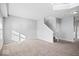 Open-concept living room with neutral walls, staircase, and carpeted floors at 10034 Evening Sun Ct, Avon, IN 46123
