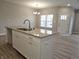 Kitchen island with granite countertop, double sink, and hardwood floors at 2331 Saddle Dr, Shelbyville, IN 46176