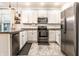Modern kitchen with stainless steel appliances, white cabinets, and tile flooring at 3047 N New Jersey St, Indianapolis, IN 46205