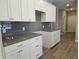 White kitchen cabinets with gray backsplash and granite counters at 2327 Saddle Dr, Shelbyville, IN 46176