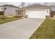 New home featuring a long concrete driveway, attached garage, and a freshly sodded front lawn at 6112 Card Blvd, Indianapolis, IN 46221