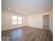 Spacious living room featuring wood-look vinyl flooring and large windows at 6112 Card Blvd, Indianapolis, IN 46221