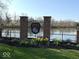 Community entrance sign for Fishers Pointe, with landscaping and a pond behind a wrought iron fence at 8010 Philadelphia Dr, Fishers, IN 46038