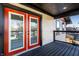 Charming balcony featuring black railing, wood flooring, and vibrant orange french doors offering an inviting outdoor space at 1015 Churchman Ave, Indianapolis, IN 46203